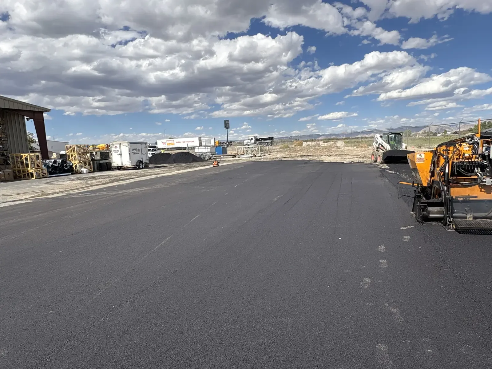 Fresh asphalt roadway with paving equipment on a commercial site — near Parker, CO