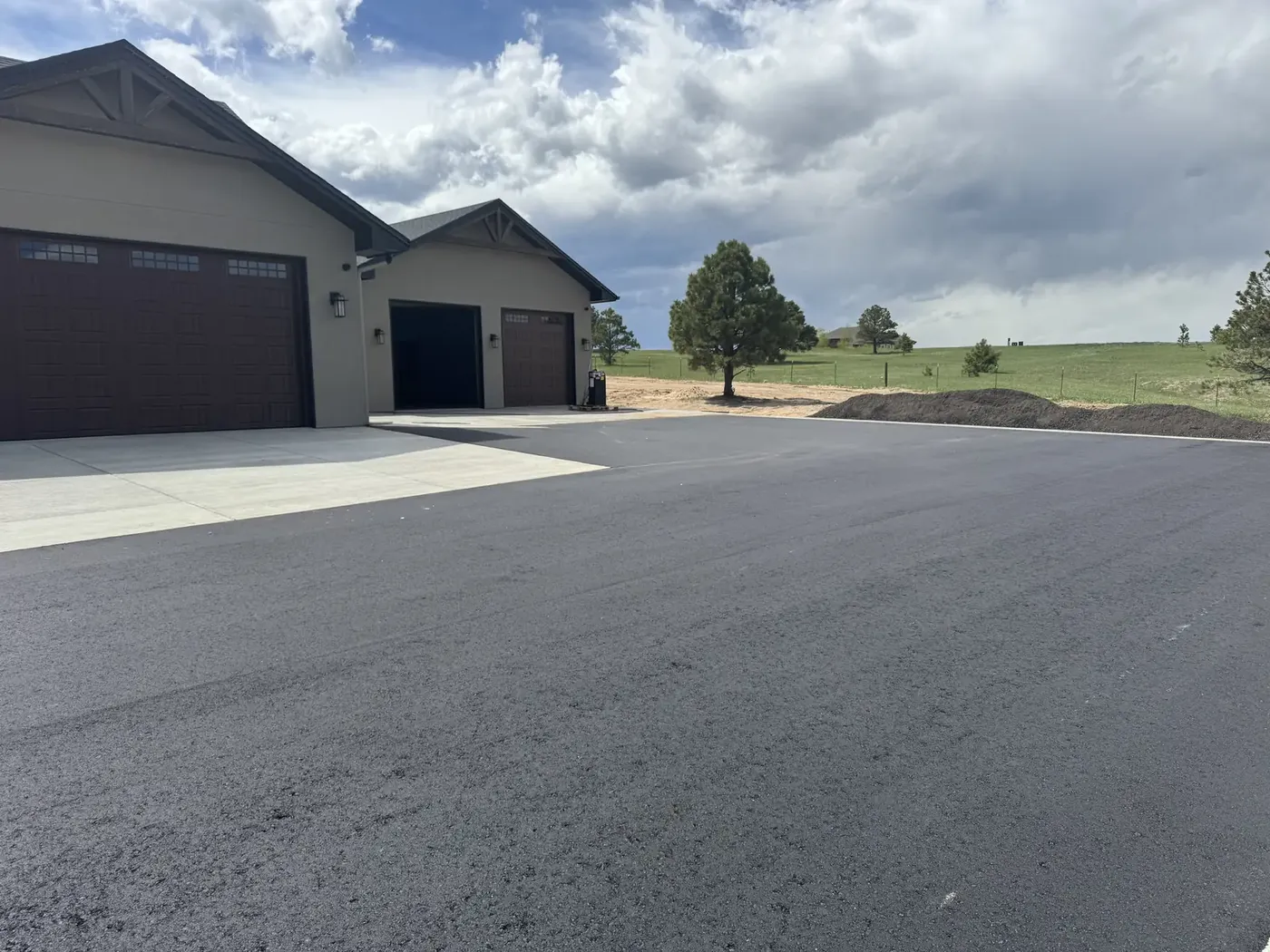 Wide new asphalt apron in front of a residential shop and garage