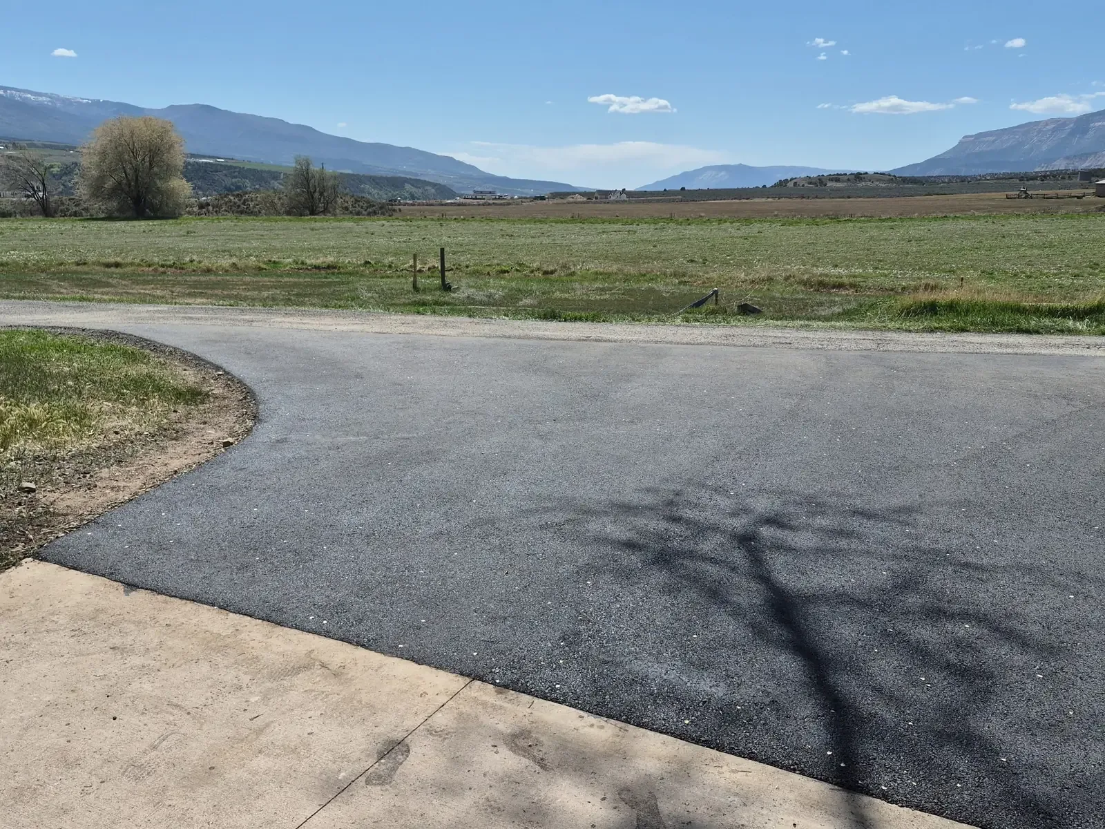 Fresh asphalt driveway with valley and mesa views — near Franktown, CO