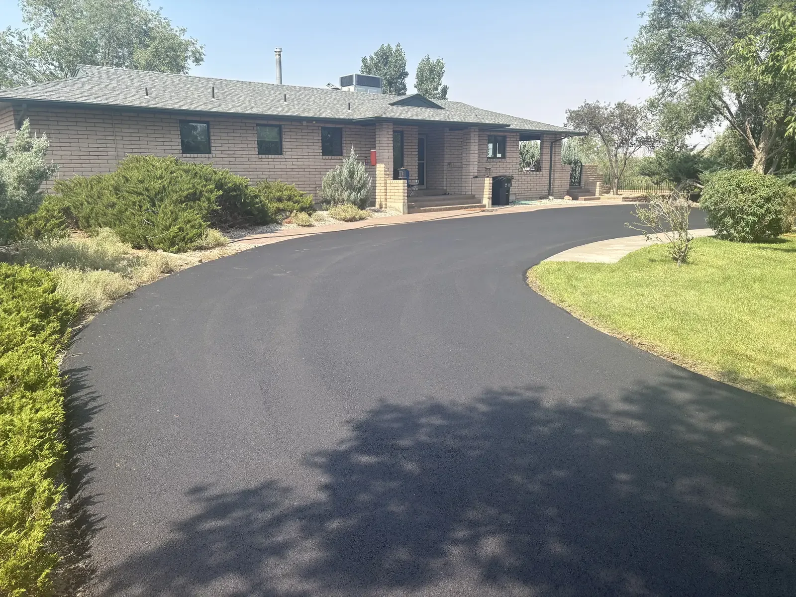 Sweeping new asphalt driveway at a ranch style home — near Monument, CO