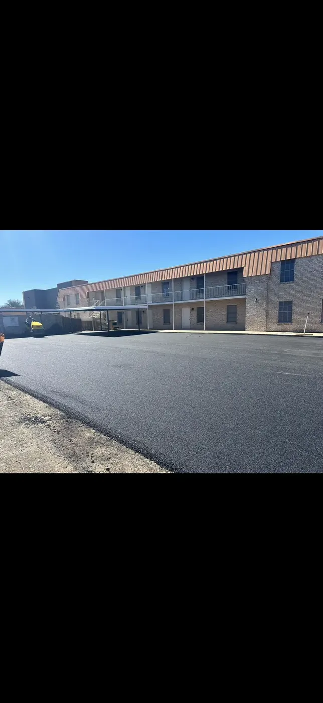 Long new asphalt drive lane at a lodging property
