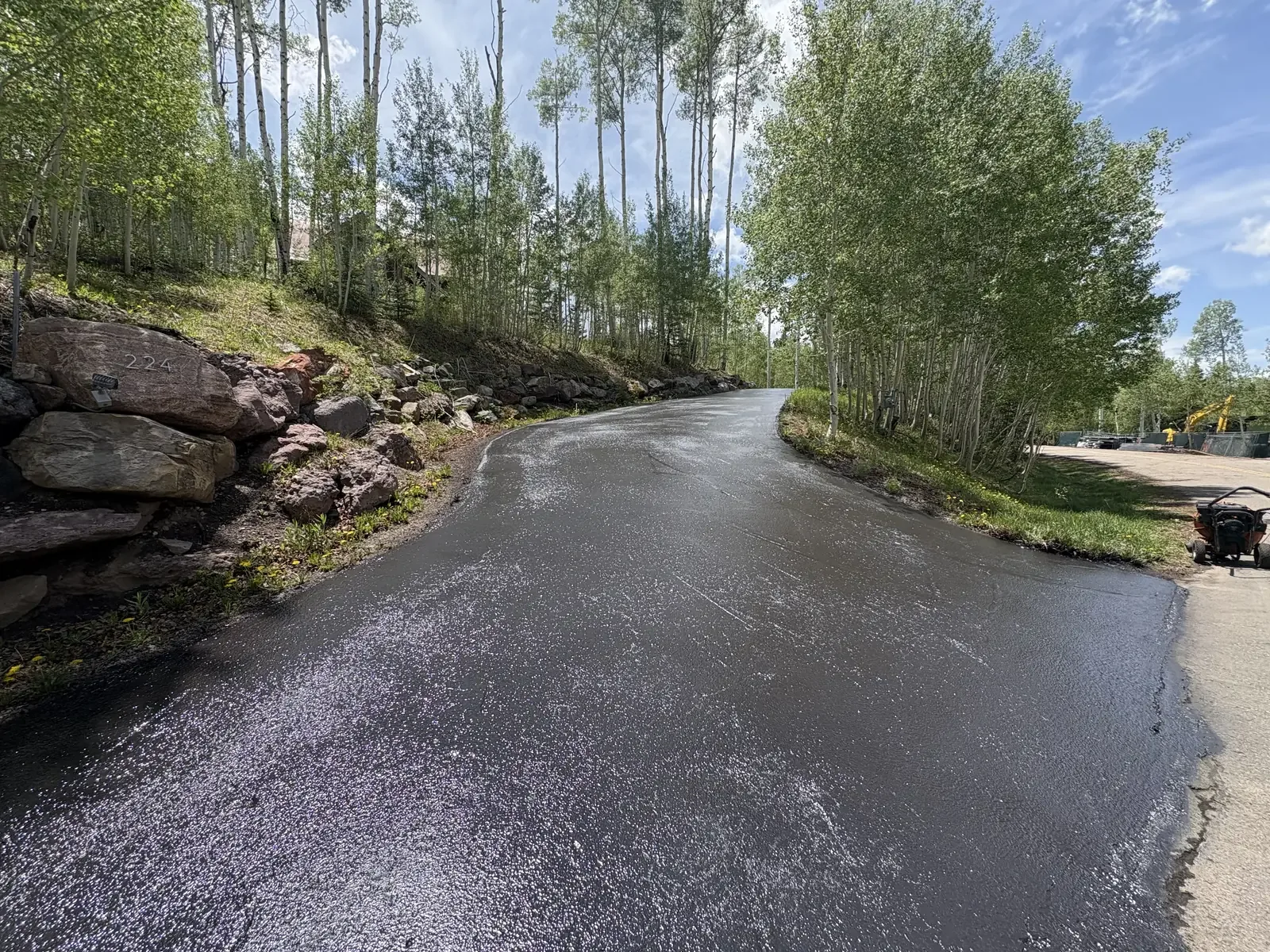 Sealed and finished driveway curving beside a rock retaining wall — near Denver, CO