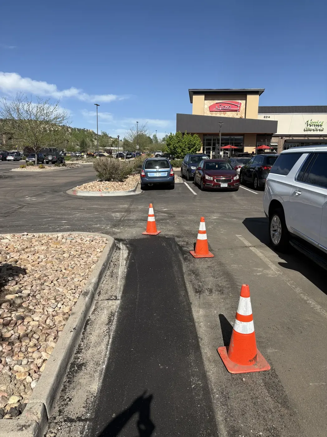 Patch work under cones in a busy retail center lot