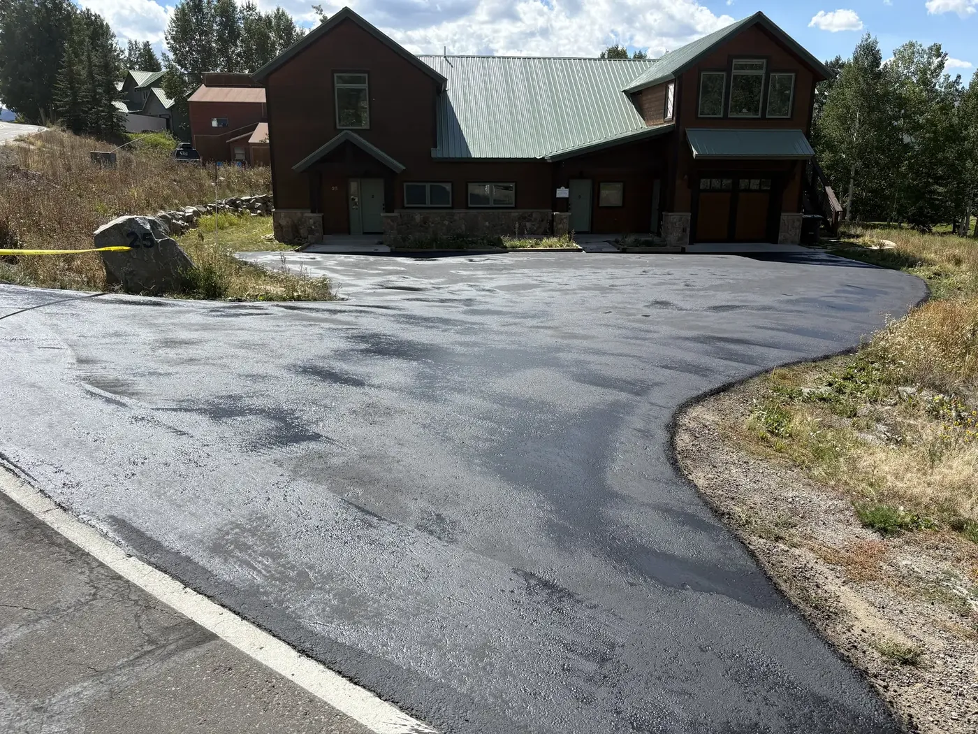 Wet sealer curing on a wide circle drive at a large home