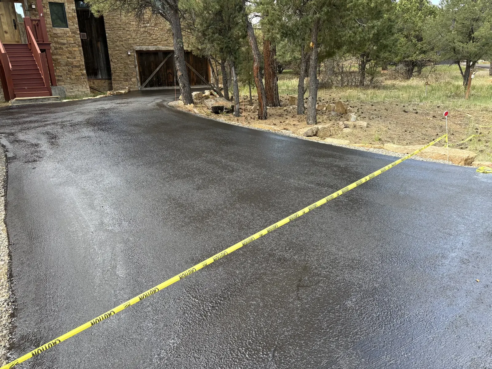 Newly seal coated parking area taped off to cure — near Elizabeth, CO