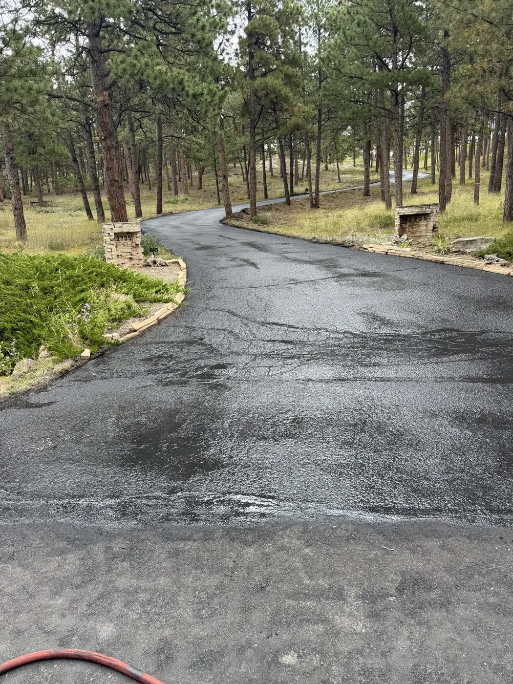 Fresh sealer being pulled across an asphalt driveway