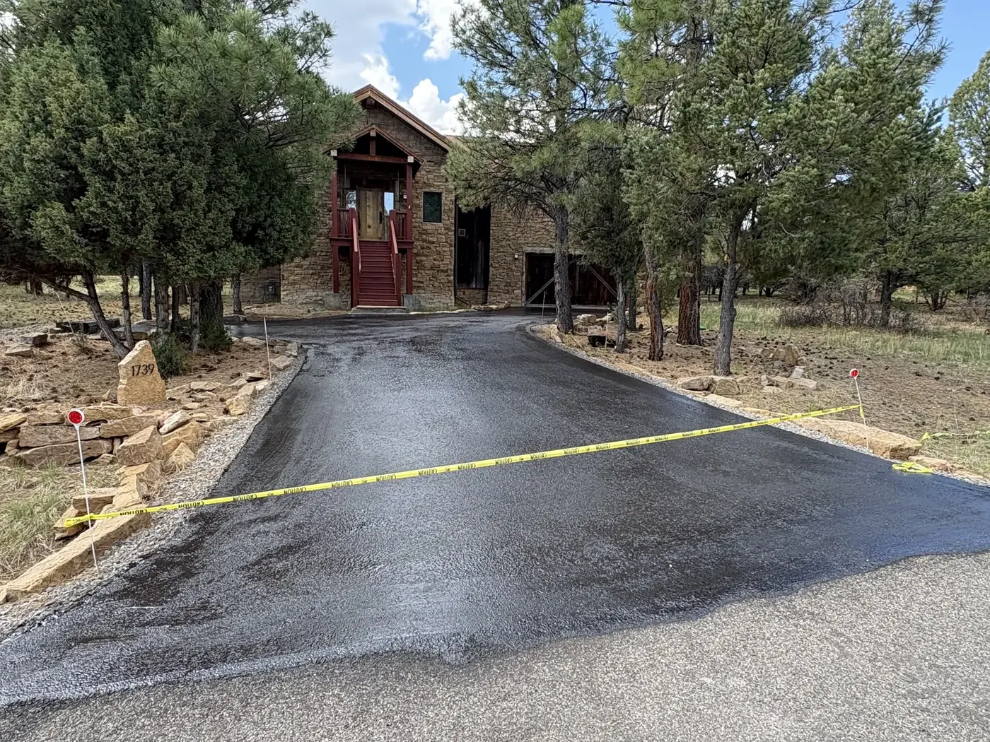 Sealed entry court and drive taped off at a stone home