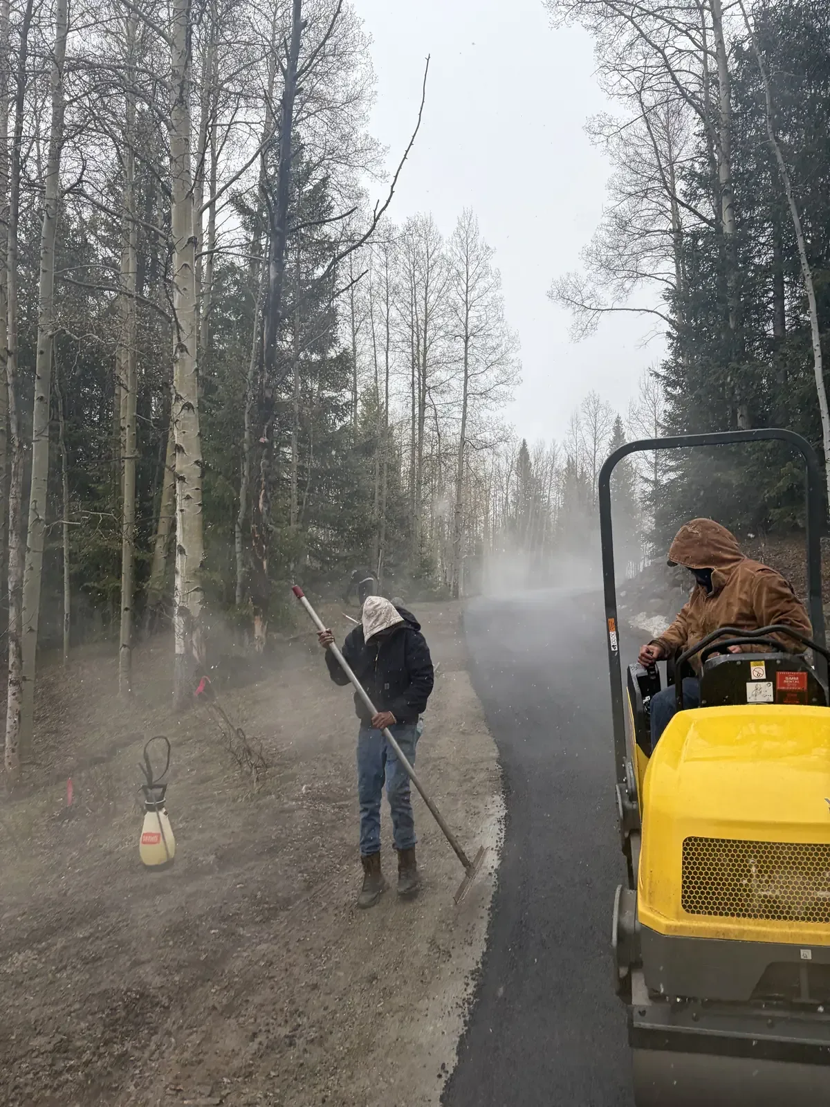 Operator sweeping and prepping a surface before chip seal
