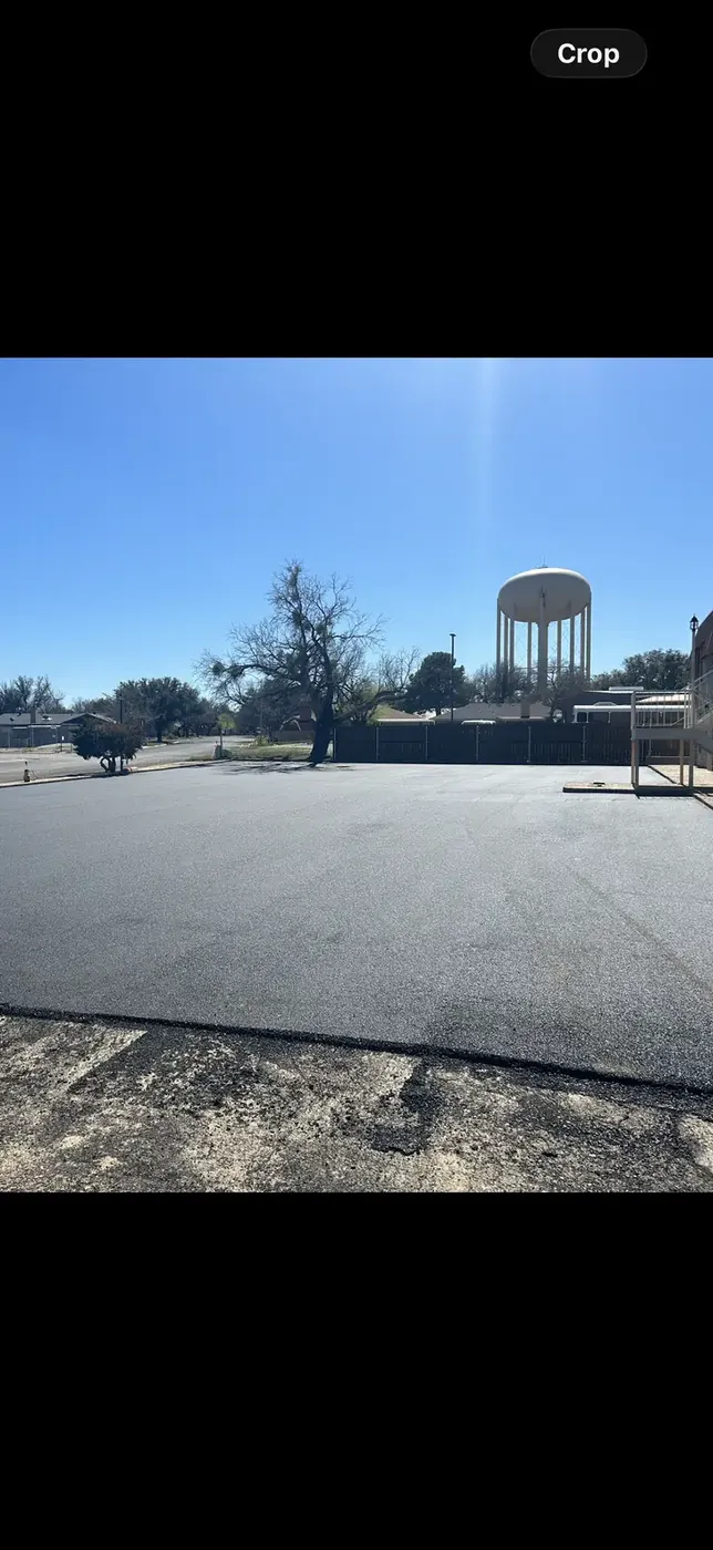 Large new asphalt lot beside a municipal water tower