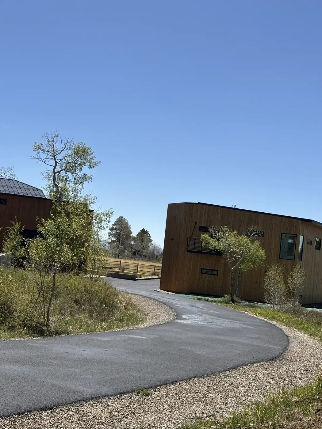 Curved new asphalt driveway at a modern ranch style home